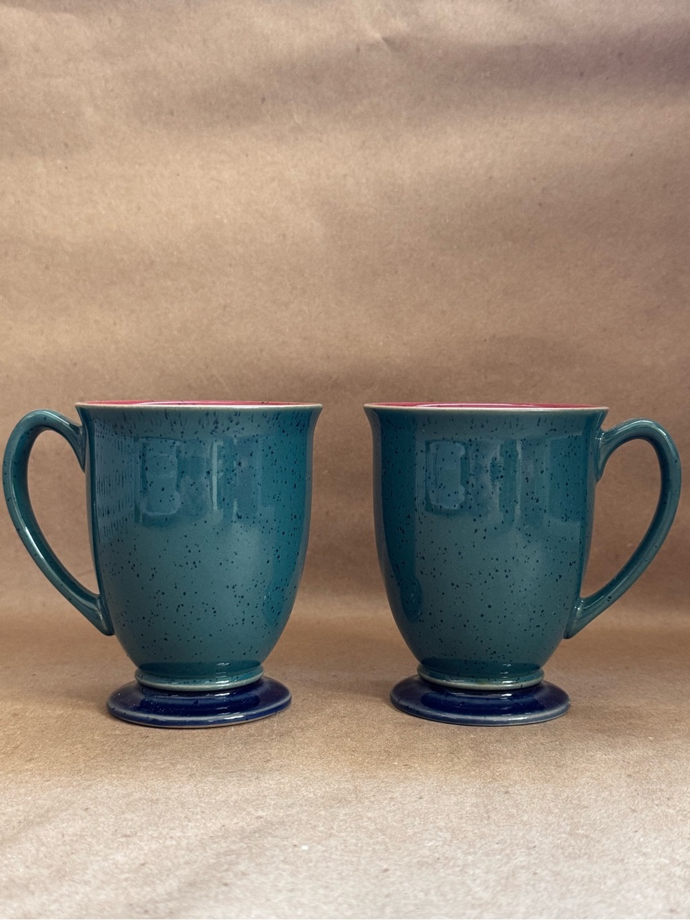 Set of 2 Denby Langley Harlequin Footed Mugs with speckled blue exterior.